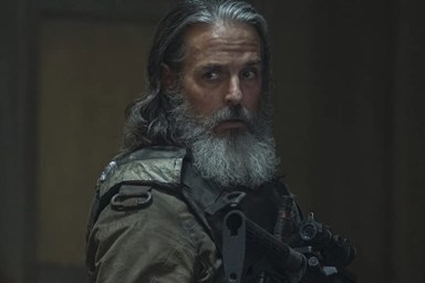 Jeffrey Pierce holds a gun in The Last of Us.