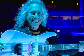Kirk Hammett from Metallica holding a guitar with DC's Joker on it