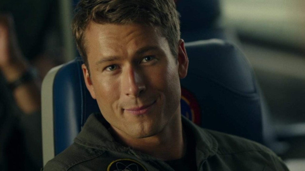 Glen Powell stares and smirks in Top Gun Maverick.