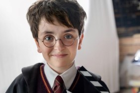A young boy dressed as Harry Potter smiles.