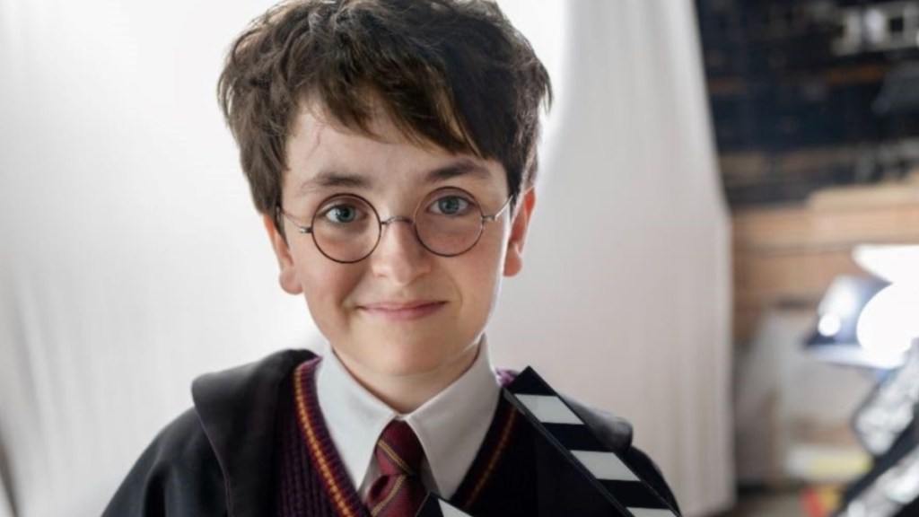 A young boy dressed as Harry Potter smiles.