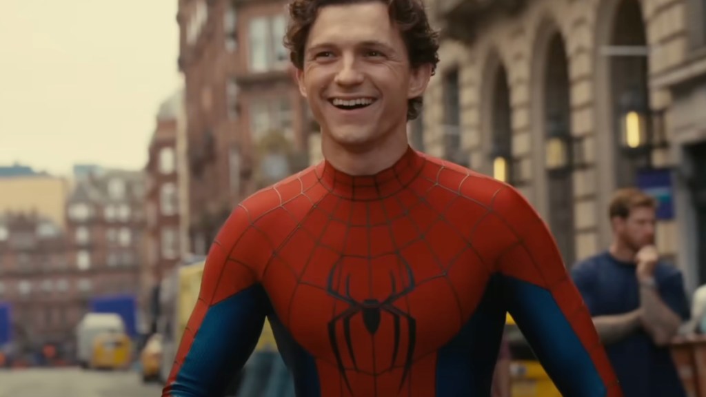 Tom Holland stands and smiles.