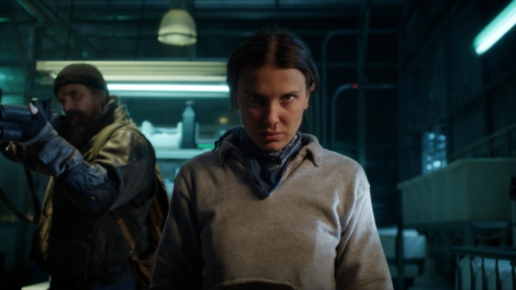 Millie Bobby Brown stands with a nosebleed.