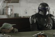 The Mandalorian and Grogu sit at a table.