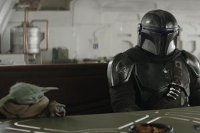 The Mandalorian and Grogu sit at a table.