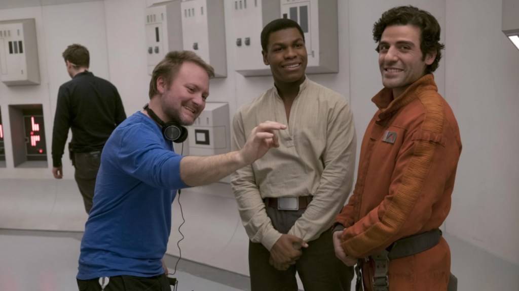 Rian Johnson stands with two actors in The Last Jedi.