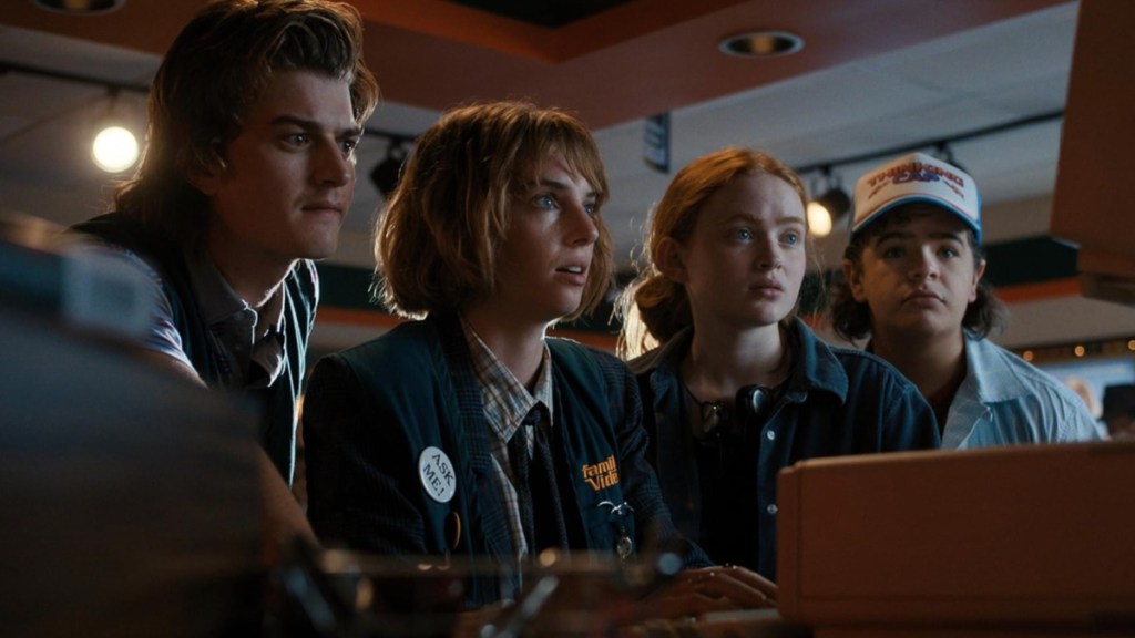 A group of kids look at a computer in Stranger Things.