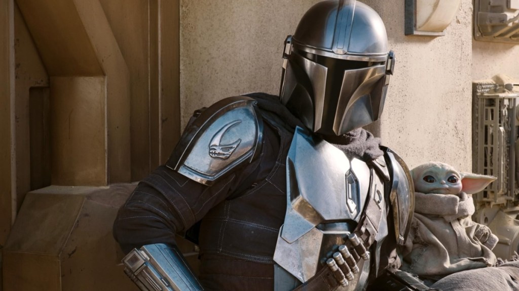 The Mandalorian stands next to Grogu.