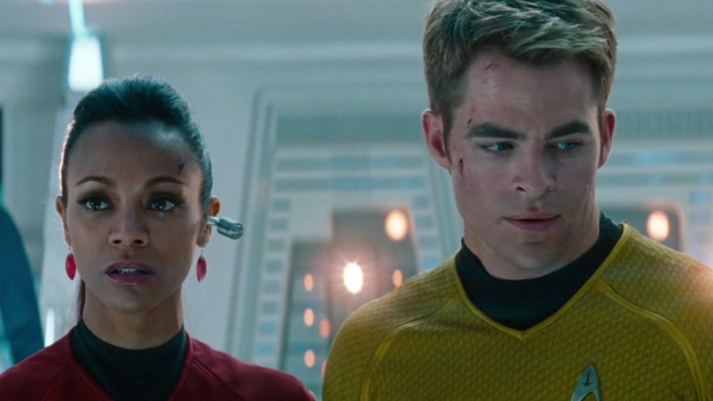 A woman and man stand next to each other and stare.