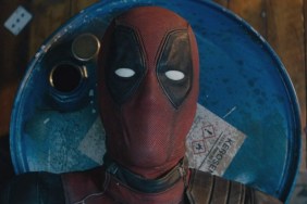 Deadpool laying on explosive barrels in Deadpool 2 opening scene