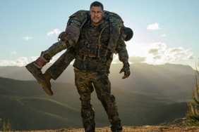 Alan Ritchson carries someone in War Machine.