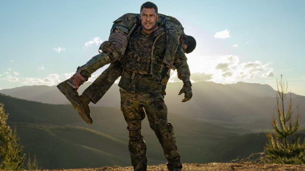 Alan Ritchson carries someone in War Machine.