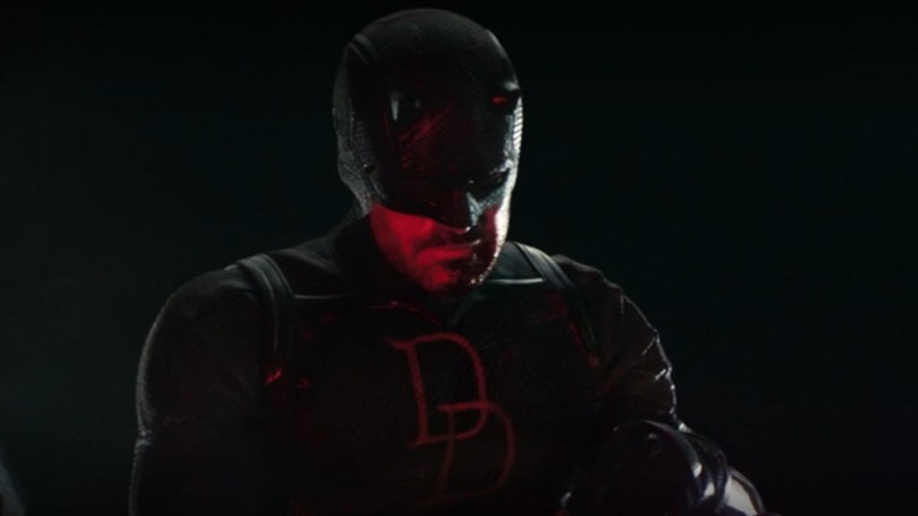 Matt Murdock in black costume observing police, lit by red light in Daredevil Season 2 Episode 2