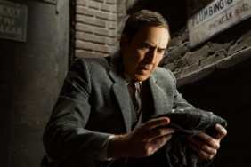 Nicolas Cage holds up a suit in Spider-Noir.