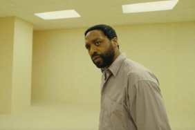 A man stands in a room and looks back in Backrooms.