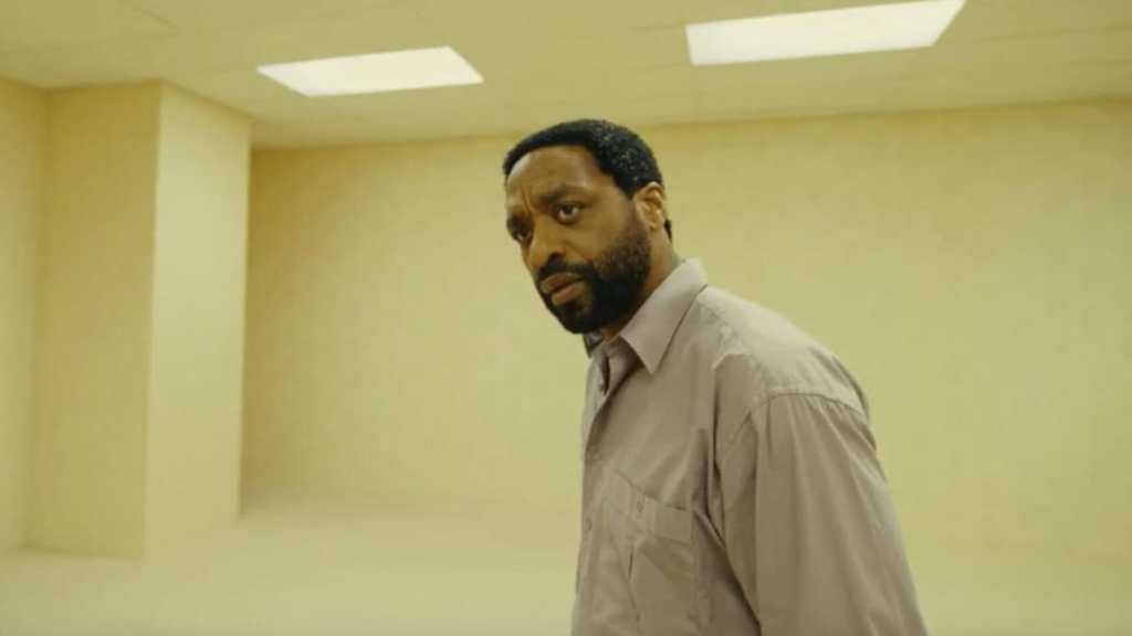 A man stands in a room and looks back in Backrooms.
