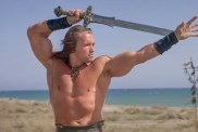 Arnold Schwarzenegger poses with sword in Conan the Barbarian movie