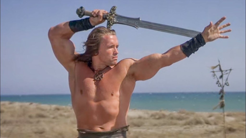 Arnold Schwarzenegger poses with sword in Conan the Barbarian movie